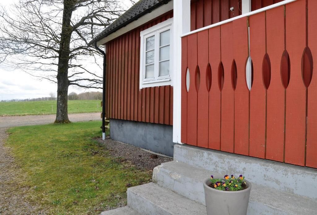 A red wooden building with a white window and a door with oval cutouts.