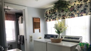A laundry room with a washing machine, dryer, and a basket of laundry. - Relax in a Peaceful Country Home in the Blue Ridge Mountains. Enjoy Local Events (Sparta)