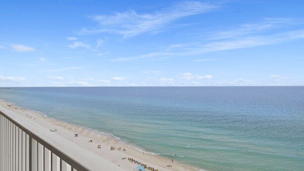 A beach with a clear view of the ocean and a distant pier. - Tropic Winds 1504 - Amazing beachfront condo! Beach chairs included! (Panama City Beach)