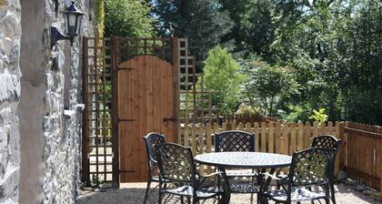 A cosy former horse stable with stone walls and old beams throughout