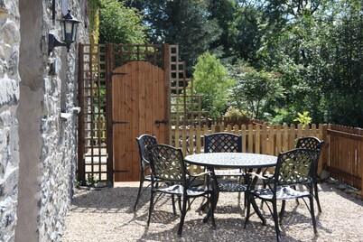 A cosy former horse stable with stone walls and old beams throughout