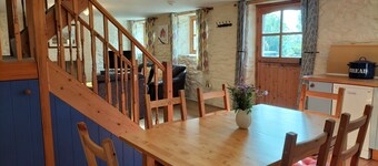 A cosy former horse stable with stone walls and old beams throughout
