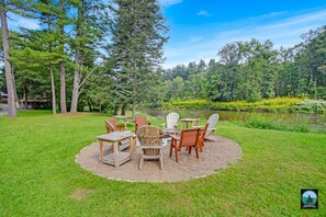 Relax in a serene outdoor setting surrounded by lush trees and a tranquil body of water.