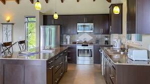 Una cocina moderna con armarios oscuros, electrodomésticos de acero inoxidable y una isla grande.