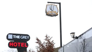 Señal que indica 'The Grey Hotel', con un letrero superior que dice 'Cactus Cafe Lounge'.