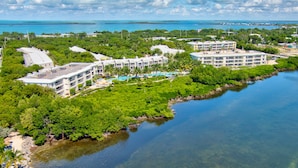 A resort with multiple buildings, a swimming pool, and a body of water. - Tropical Escape at Mariner’s Club  2BR Key Largo Condo w/ Pools & Marina (Key Largo)