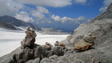 A glacier with rocky terrain and distant mountains.