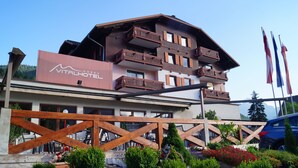 A multi-story building with balconies, a wooden fence, and a sign for 'BOSAU VITALHOTEL'. - Apartment Hallstatt Dachstein Inn (Gosau)