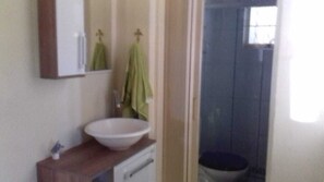 Ein Badezimmer mit Waschbecken, Spiegel und Handtuchhalter.