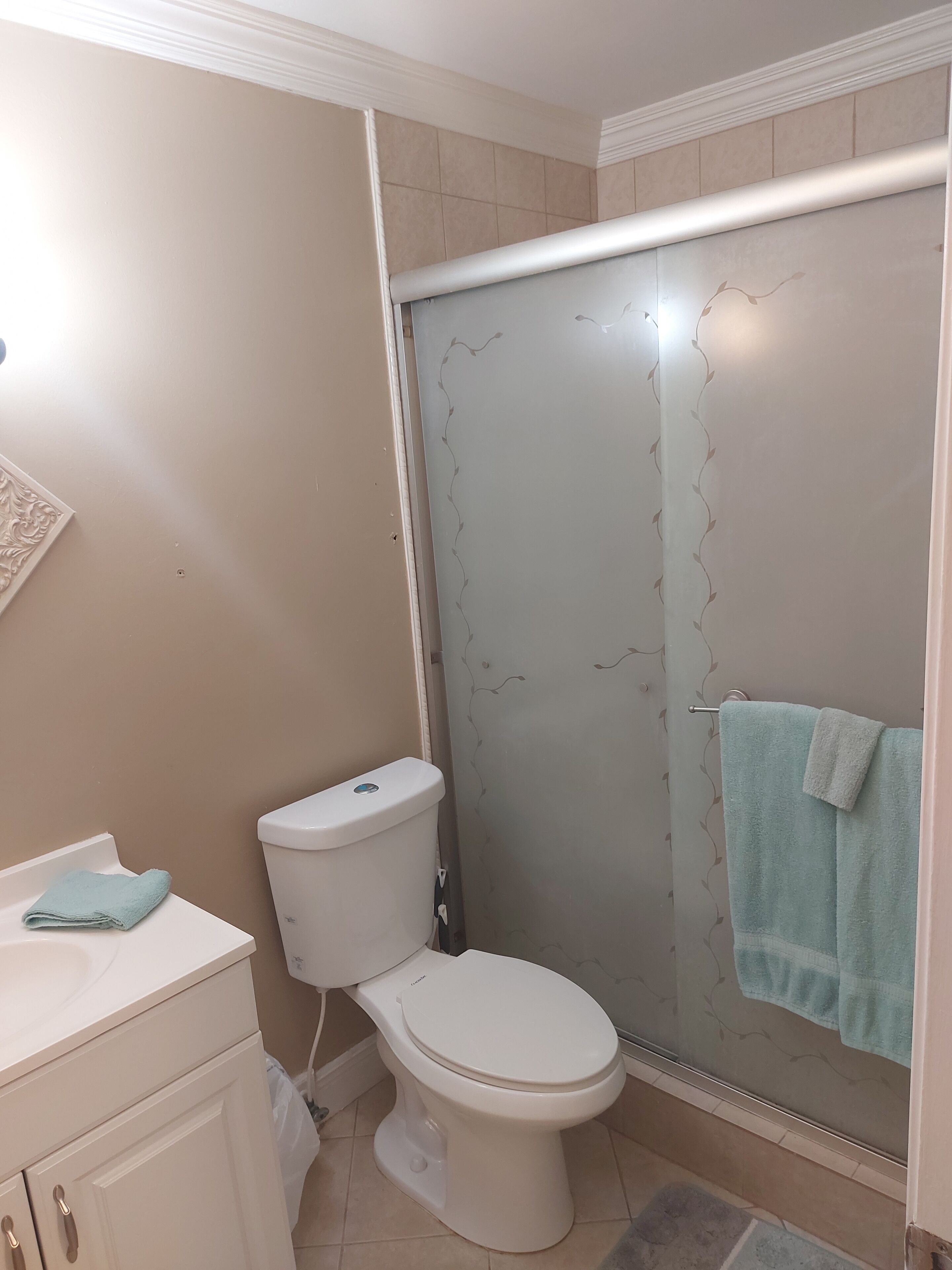 Une salle de bain comprenant des toilettes, un lavabo et un espace douche.