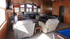 A spacious living area with a pool table, leather sofas, and a dining area with chairs and a table. - Last Minute Special/ Elevator/Pool/Theater/Game Rm/Pool table/ping pong table (Nags Head)