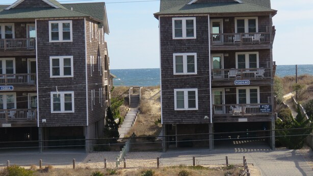 Two multi-story buildings with balconies, a beach view, and a sign for 'Pompano Village for Rent'. - Last Minute Special/ Elevator/Pool/Theater/Game Rm/Pool table/ping pong table (Nags Head)
