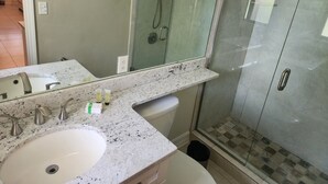 A bathroom with a double sink, a glass-enclosed shower, and a mirror above the sink. - Bayshore Inn & Docks Two Bedroom Unit 8 Overlooking the Pool (Naples)