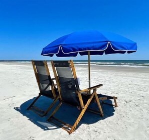 Relax in comfort under a shaded retreat on the sandy beach.