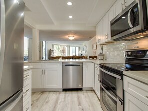 Enjoy cooking in this well-equipped kitchen with a refrigerator, dishwasher, oven, and microwave.