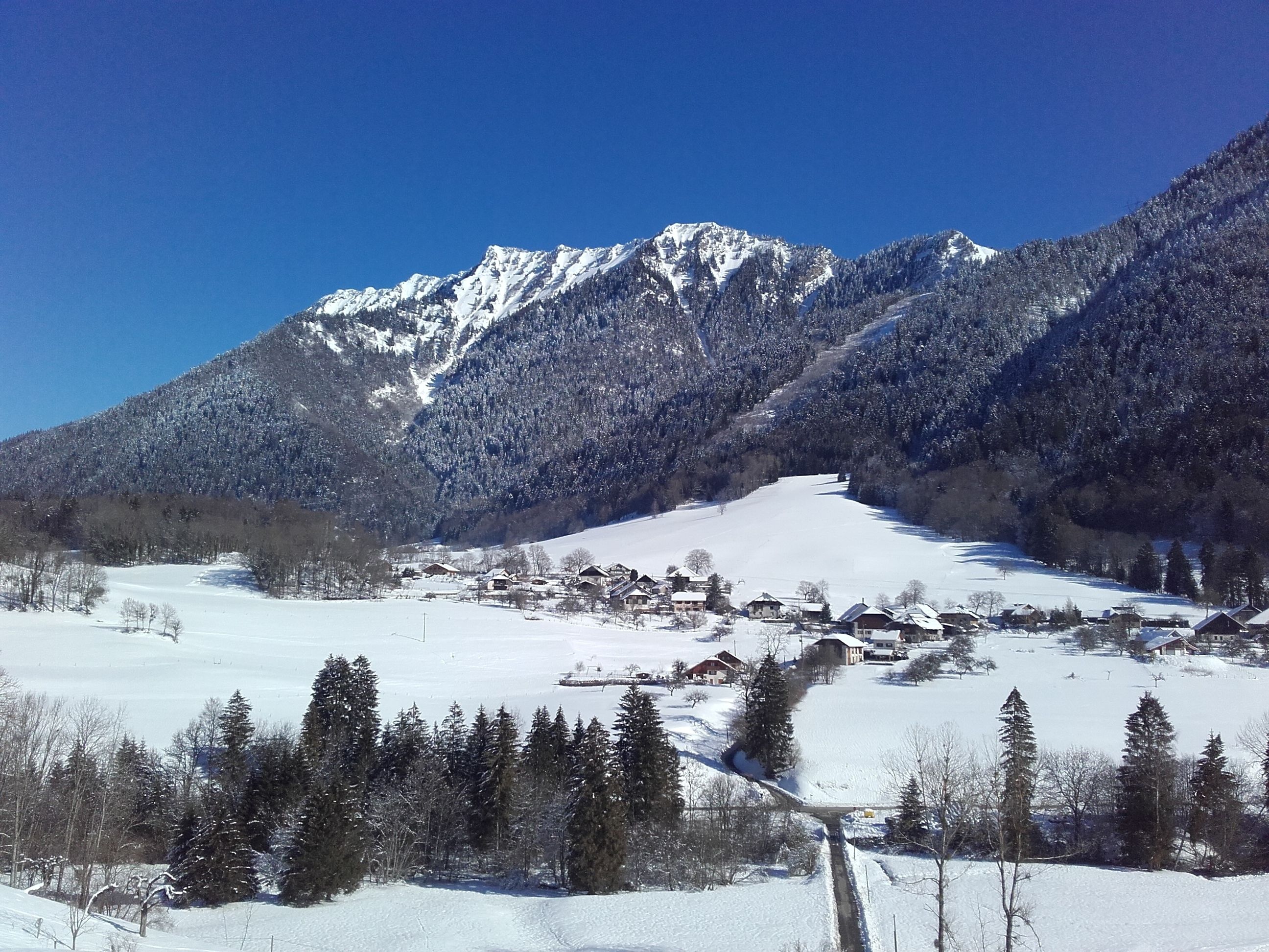 A snow-covered mountain landscape with a small village in the valley.