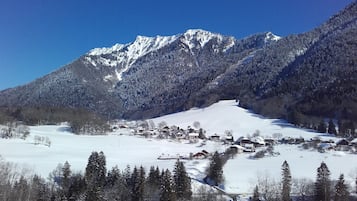 A snow-covered mountain landscape with a small village in the valley.