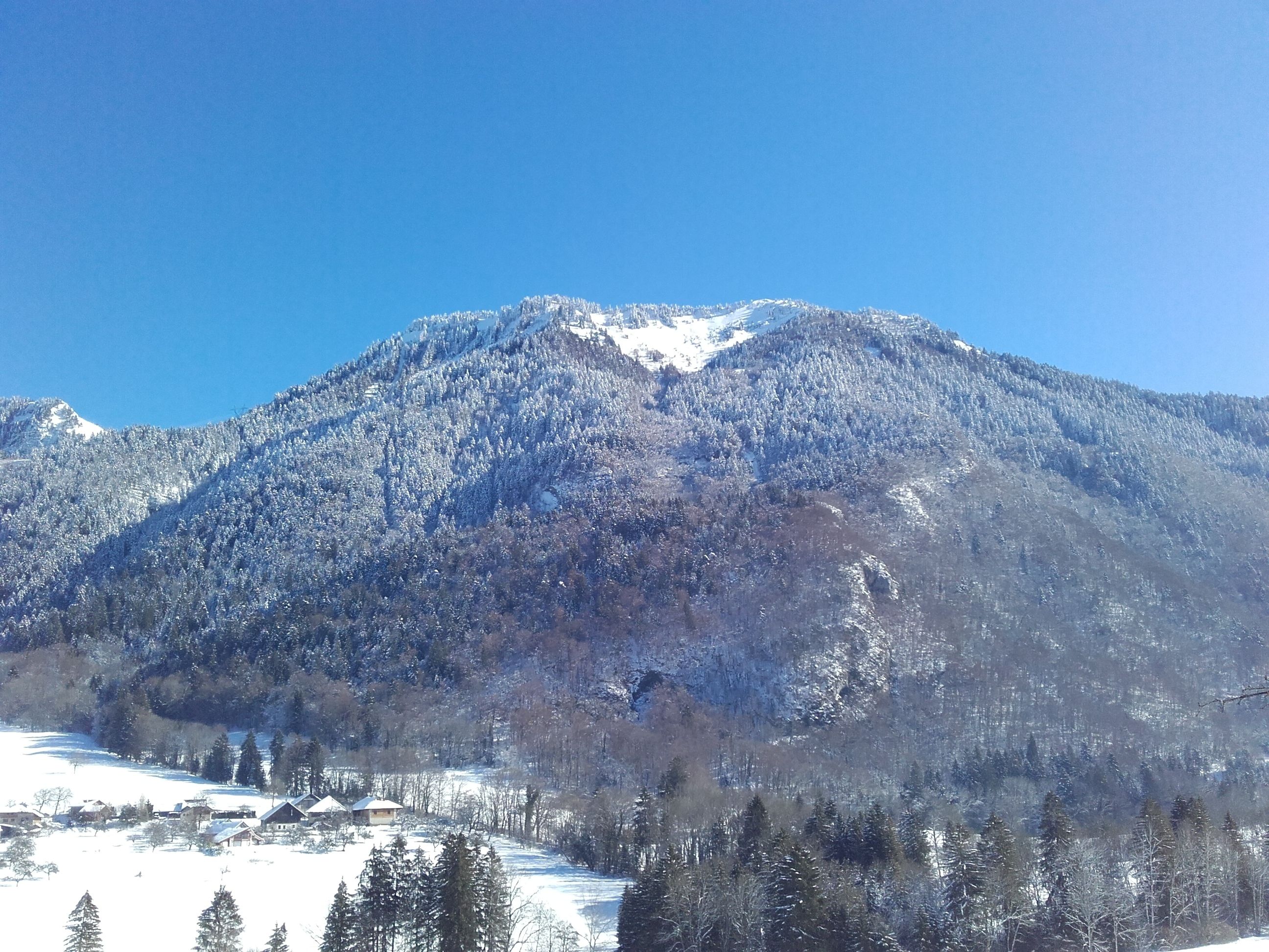 Une montagne enneigée sous un ciel dégagé.