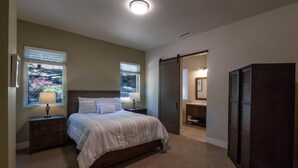 Ein Schlafzimmer mit Bett, Nachttischen, Kommode und Schiebetürenschrank.