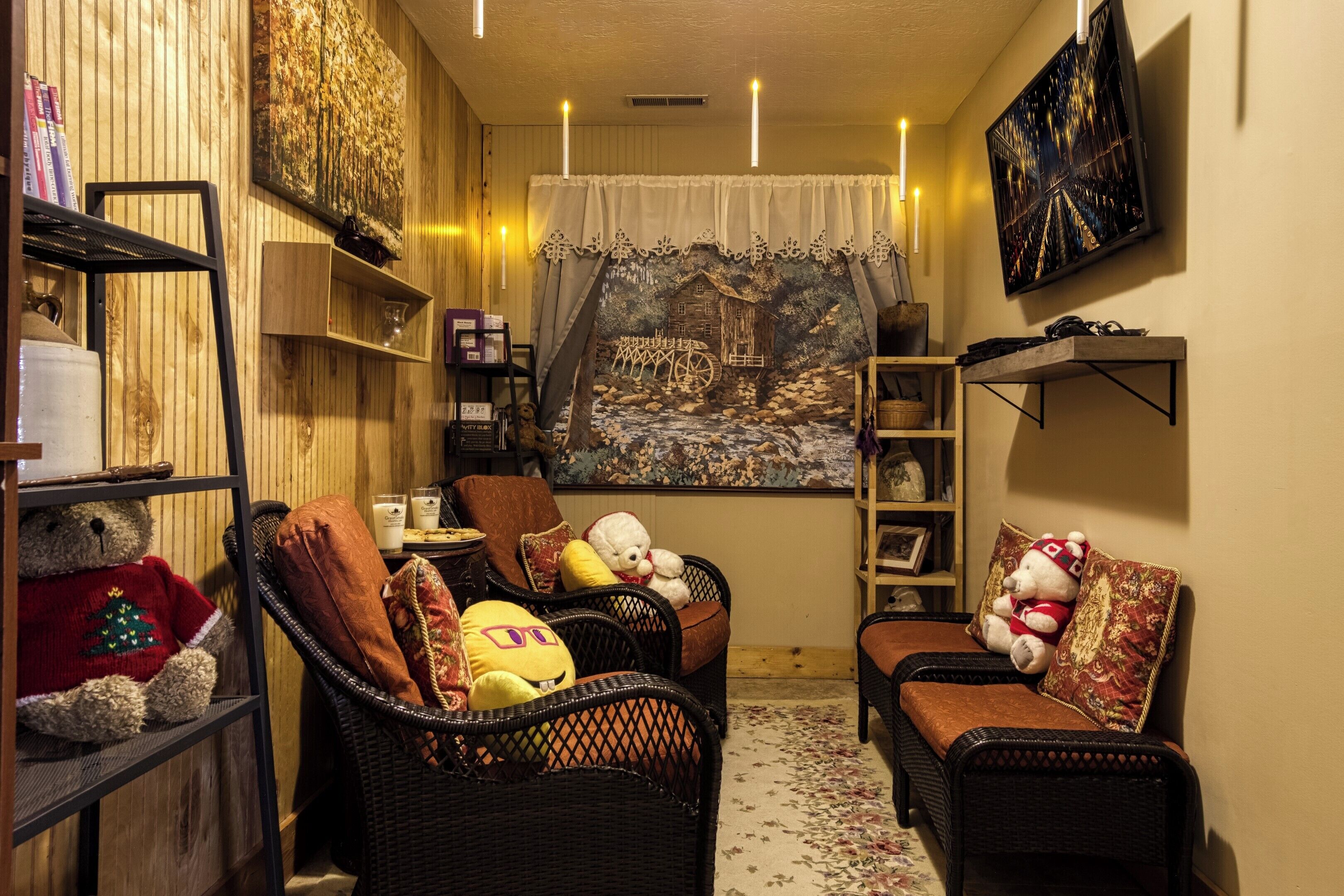 A cozy living room with wicker furniture, a teddy bear, and a tapestry.
