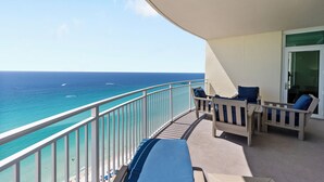 A balcony with a view of the ocean, a white railing, and two wooden chairs with cushions. - Aqua 2102 Luxury Gulf Front Escape, Beach Chairs, Walk to Pier Park (Panama City Beach)