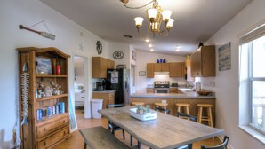 A kitchen with wooden cabinets, a dining table, and bar stools.
