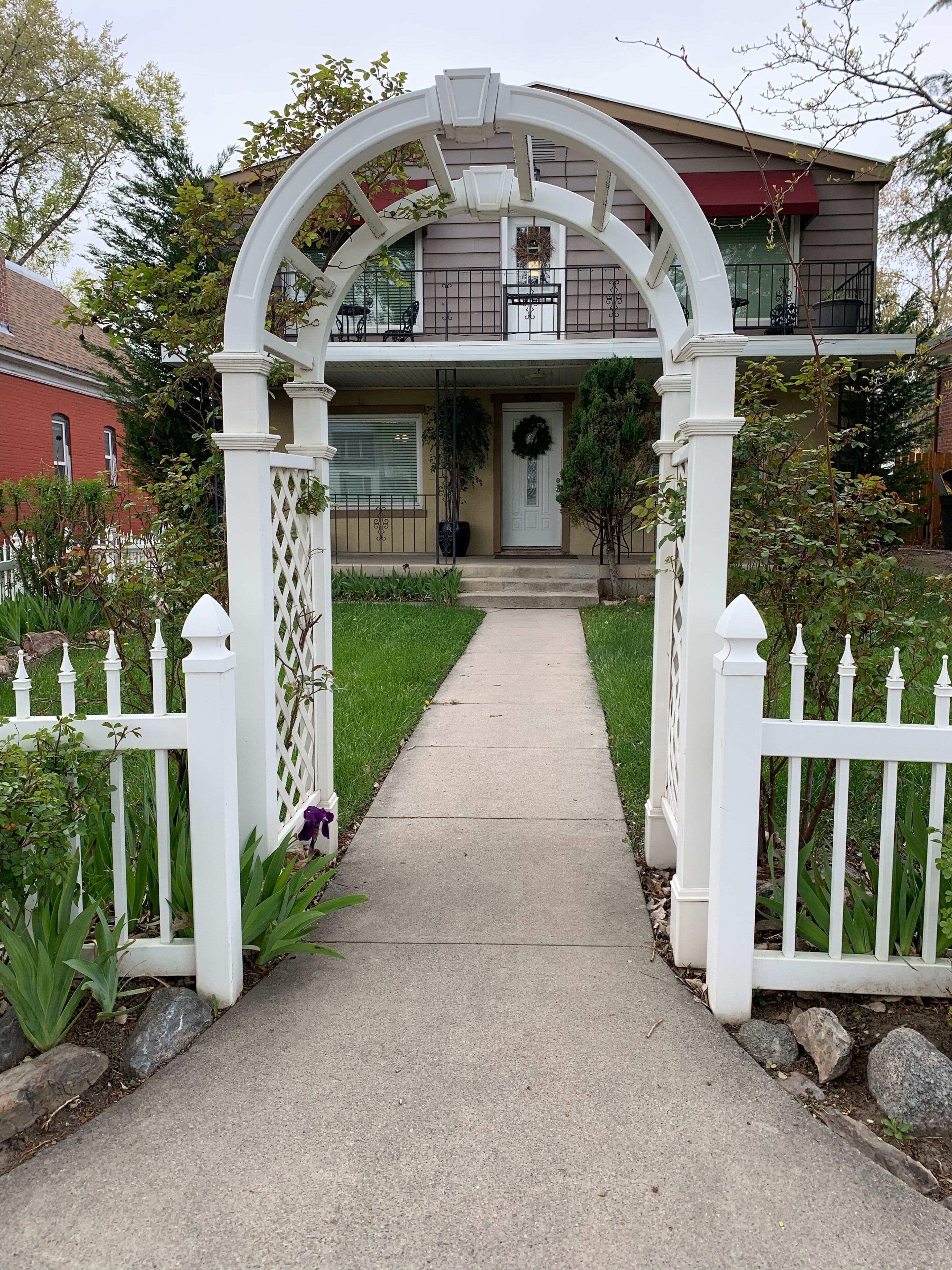 Arbored entrance from sidewalk into yard.