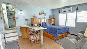 A compact room with a bed, a desk, a chair, a sofa, and a small kitchenette. - Fisherman's Get-A-Way! Cozy waterfront retreat with access to Lake Okeechobee! (Okeechobee)