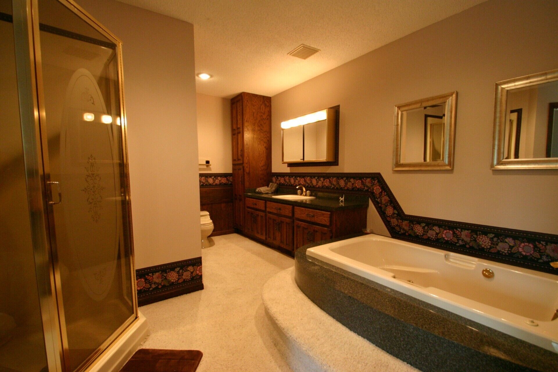 Master bath with jetted tub, separate shower, two vanities, and two toilets