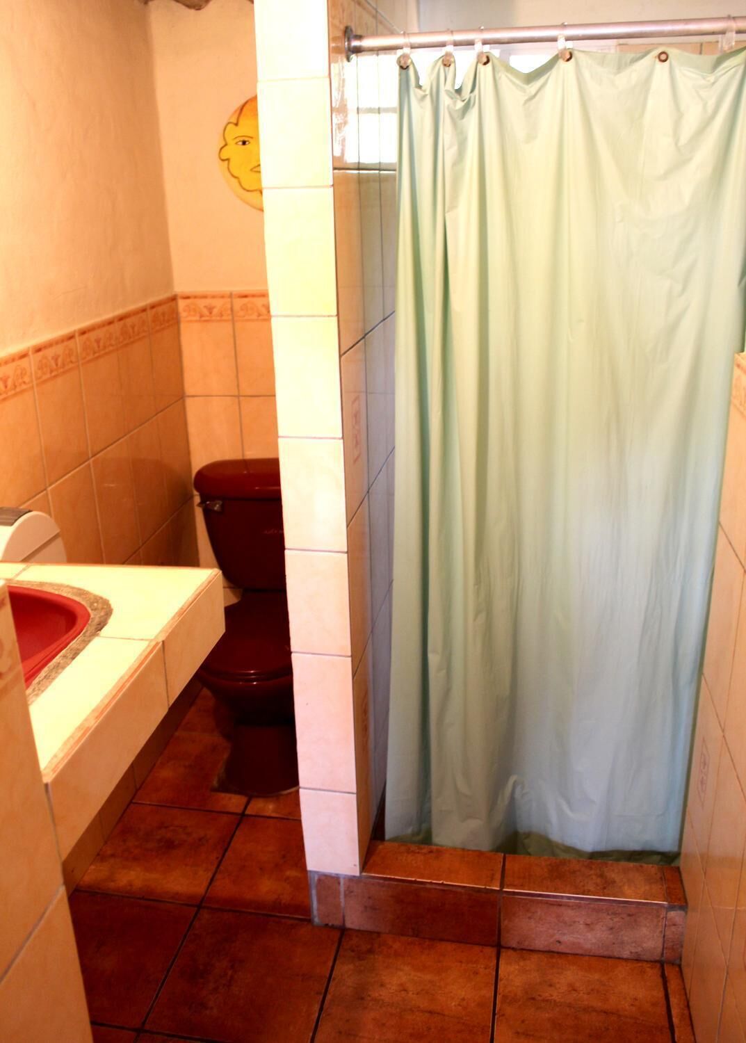 A bathroom with a toilet, a sink, and a shower curtain.