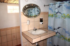 A bathroom with a sink, mirror, and shower curtain. - Capricho Beach House (Jujutla)