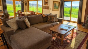 Una sala de estar con un sofá modular, una mesa de centro y un comedor con mesa y sillas.