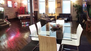 A spacious living area with a glass-top dining table surrounded by chairs, a leather sofa, and a billiards table. - Up to 50% off for limited time! Professionally Cleaned, Pool & Foosball Table (Nashville)