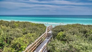 A wooden boardwalk leading to a beach with clear turquoise waters and lush greenery. - Stylish Coastal Retreat | Large Balcony w/Views | Steps to Beach Club & Pools (Santa Rosa Beach)