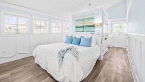 A bedroom with a large bed, white walls, and a ceiling fan. - Stylish Coastal Retreat | Large Balcony w/Views | Steps to Beach Club & Pools (Santa Rosa Beach)
