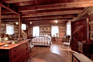 Une chambre à coucher rustique en bois, avec un lit, une commode et une chaise.