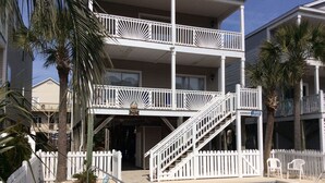 Un hôtel en bord de mer doté d’une piscine, de rampes blanches et de palmiers.