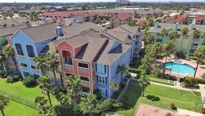 A residential area with multi-story buildings, a swimming pool, and well-maintained lawns.