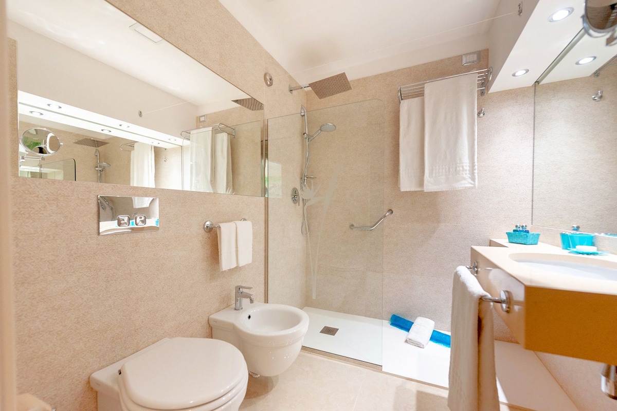 Un baño moderno con inodoro, bidé, ducha y lavamanos.