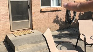 Une terrasse avec deux chaises en métal et un sol en béton.