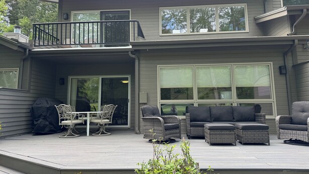 A two-story house with a balcony, outdoor seating, and large windows. - Beautiful Townhome Near Glacier Park!! (Columbia Falls)