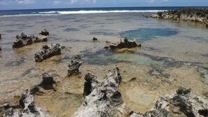 A beach with clear shallow waters and rocky formations. - Newly Renovated Turtle Bay Condo! Enjoy All The North Shore Has To Offer! (Kahuku)