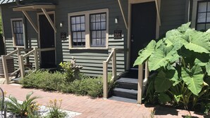 Een huis met een veranda, een welkomstbord en een trap naar de deur.