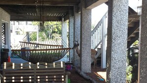 A covered outdoor area with a hammock, a wooden bench, and a sand play area with toys. - Relax by the Sea! Wide Beach! Beautiful view from porch. (Fripp Island)