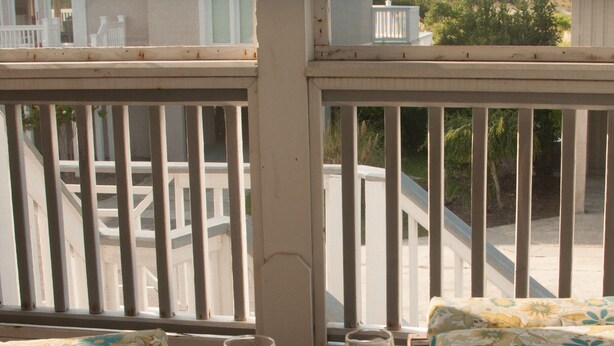 A balcony with two wicker sofas and a small table, each with a glass of amber liquid. - Relax by the Sea! Wide Beach! Beautiful view from porch. (Fripp Island)