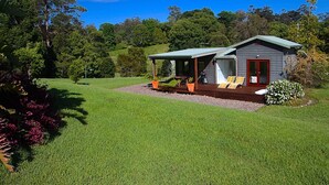 A small house with a porch, a deck, and a lawn. - Afterglow offers romance, luxury and indulgence amid the quiet beauty of nature (Kalang)