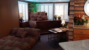 A cozy room with a bed, a desk, and a window with shutters.