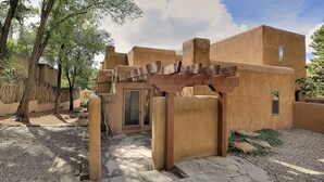 Un edificio con un sendero de piedra que lleva a una pérgola de madera.