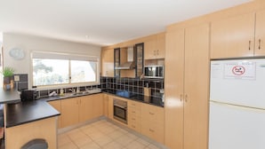 Una cucina moderna con mobili in legno, un piano di lavoro nero e un forno integrato.