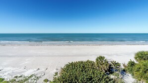 Ein Strand mit blauem Himmel und ruhigem Wasser.